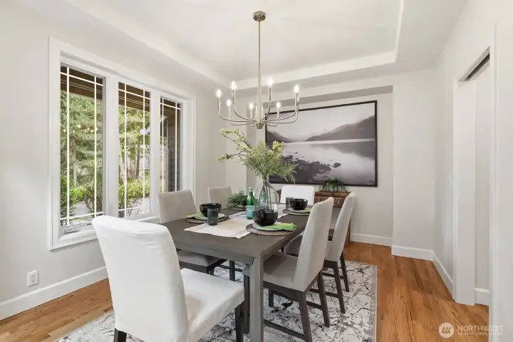Sophisticated formal dining room with a striking tray ceiling and stylish updated lighting.