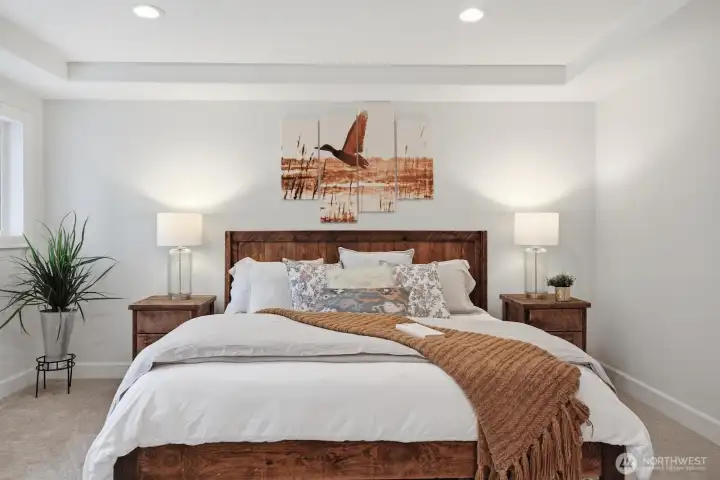 Spacious primary suite with two walk-in closets, sophisticated tray ceiling accents and fresh paint.