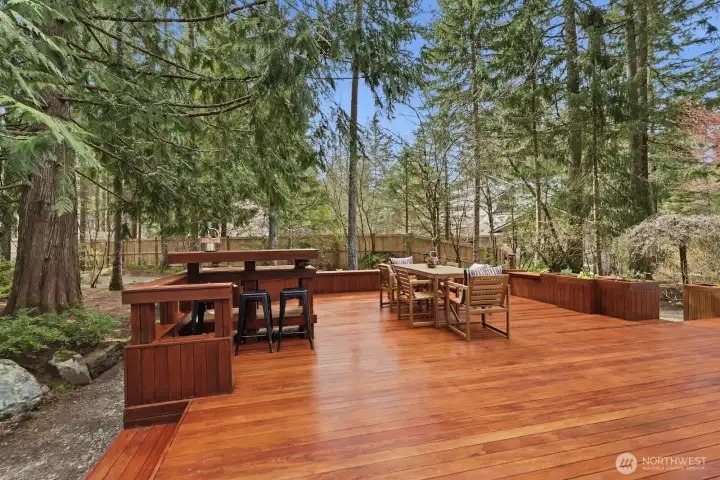Gorgeous and grand custom ironwood wraparound deck with multiple tiers, designed for outdoor entertaining and scenic enjoyment.