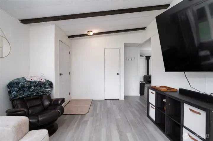 Comfortable living area with modern flooring, clean lines, and ample wall space for entertainment setup. A versatile space for relaxing or hosting guests.