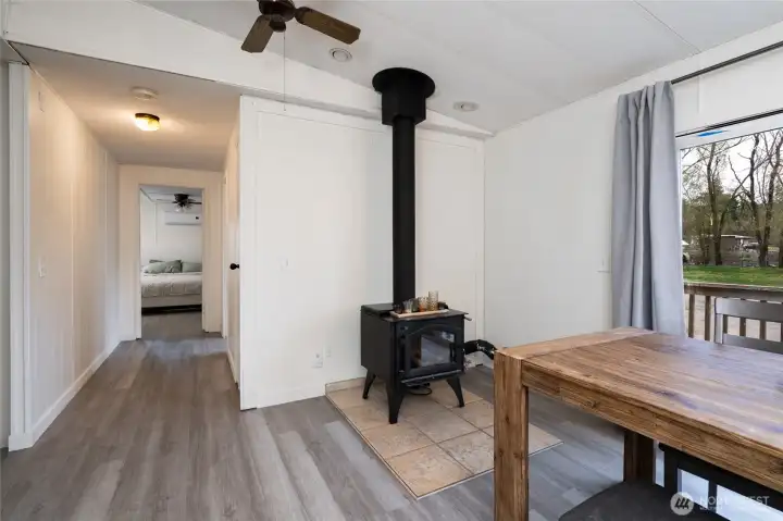 Bright dining area with cozy wood stove.