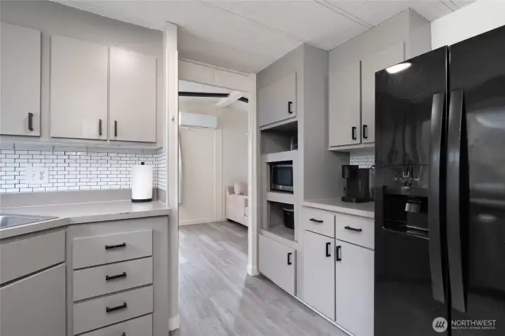 Spacious kitchen with an open-concept design, showcasing stainless steel appliances, abundant counter space, and a large window that fills the room with natural light. The neutral color palette and updated finishes create a warm, inviting atmosphere.