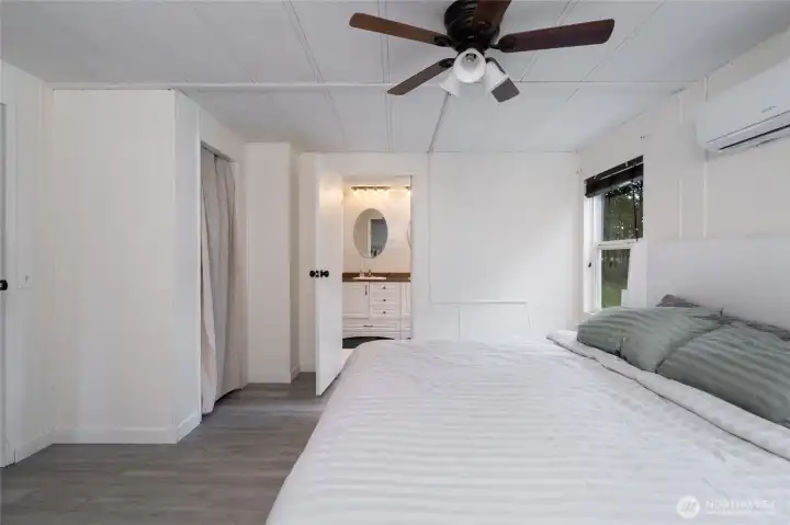 Bright and airy primary suite with direct access to a private ensuite bathroom. Clean white panel walls and updated flooring create a fresh, move-in-ready feel.