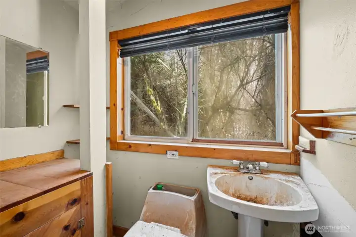 Three-quarter bath with window for natural light and compact layout. Ideal opportunity for a full refresh to add value and functionality.