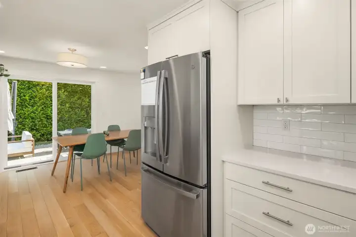 Open-concept kitchen and dining area with stainless steel appliances, custom cabinetry, hardwood floors, and seamless flow for everyday living and entertaining.