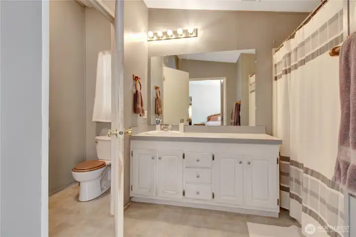 Primary bedroom has a fully equipped bathroom, with storage, and bi-fold doors for privacy when needed.