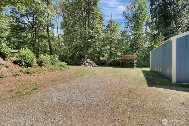 Side parking, with access to the woodshed! Dry creek bed is just beyond the tree line.