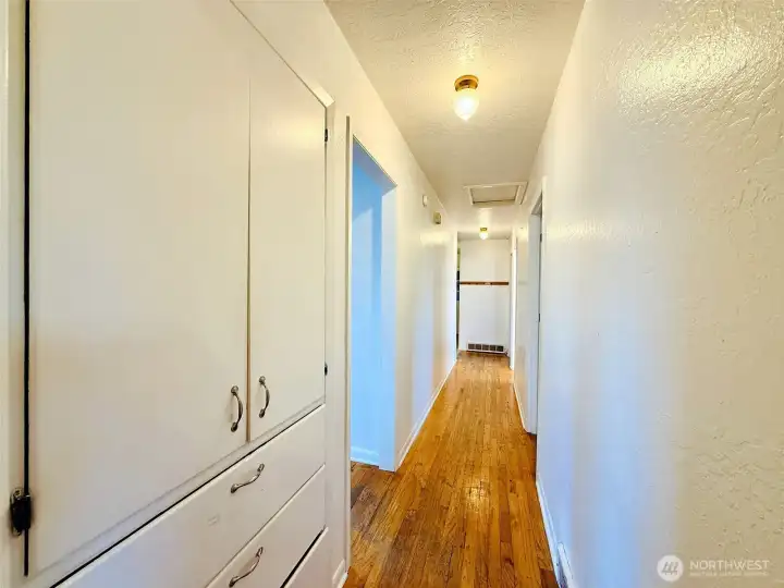 Main floor hallway with built in storage, access to the three bedrooms and full bathroom Main floor hallway with built in storage, access to the three bedrooms and full bathroom