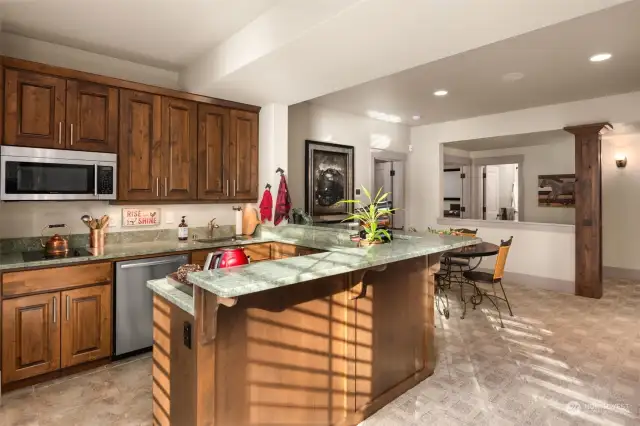 The lower level's second kitchen features microwave, electric cooktop, dishwasher and mini fridge.