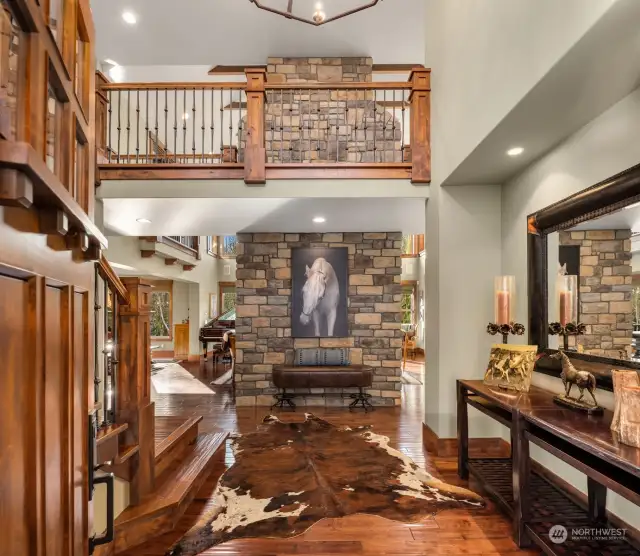 Vaulted entry features grand two-story fireplace, contemporary craftsman architecture with lux woodwork, hardwood flooring and upgraded lighting.