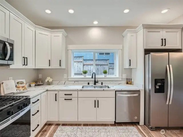 Kitchen equipped with shaker cabinets, a high-performance gas stove, and quartz countertops.