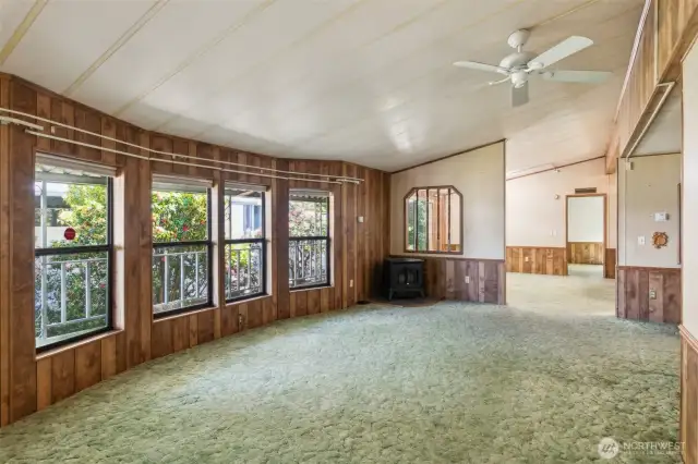 Inside an expansive wall of windows brings an abundance of natural light to the living area. Vaulted ceilings add to the feeling of openness.