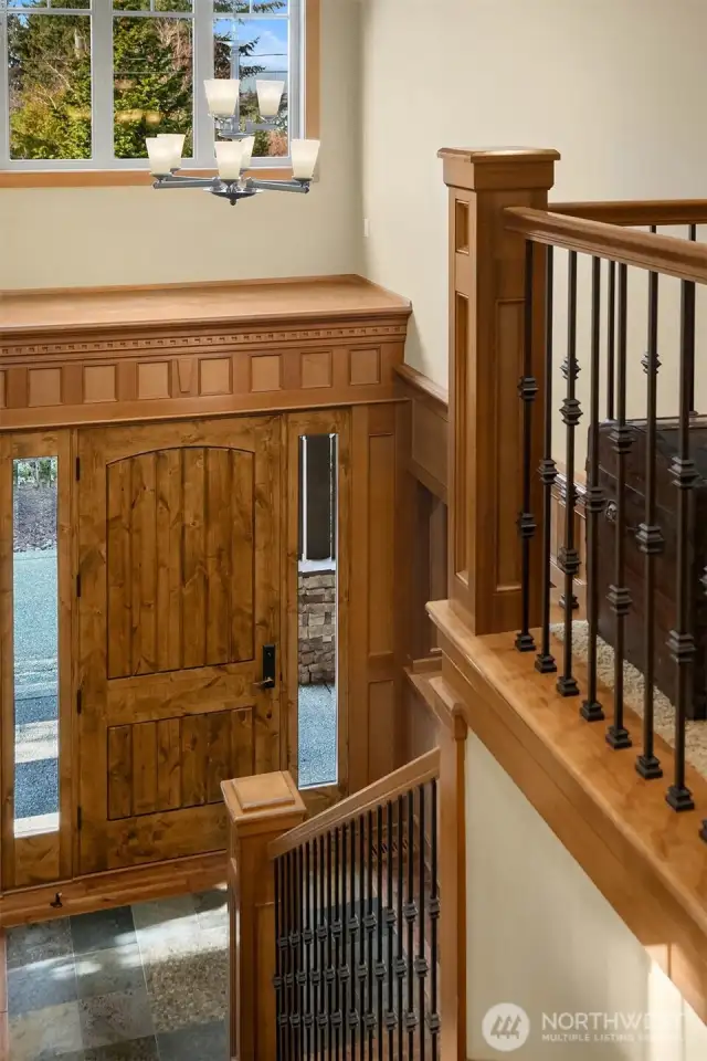 A stunning vaulted entry foyer, and main staircase to the upper-floor with wrought iron balusters.