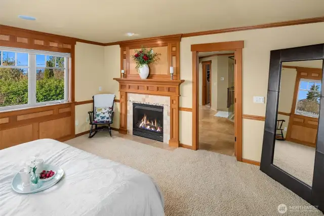 The elegant and relaxing primary suite offers a fireplace and inspiring sunsets, views of the Seattle skyline and Olympic Mountains on clear days.