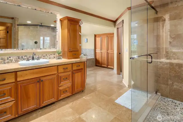 The large en suite spa-inspired bath with frame-less glass door double shower, Travertine tilework, heated floors, jetted tub, and huge cedar-lined walk-in closet.