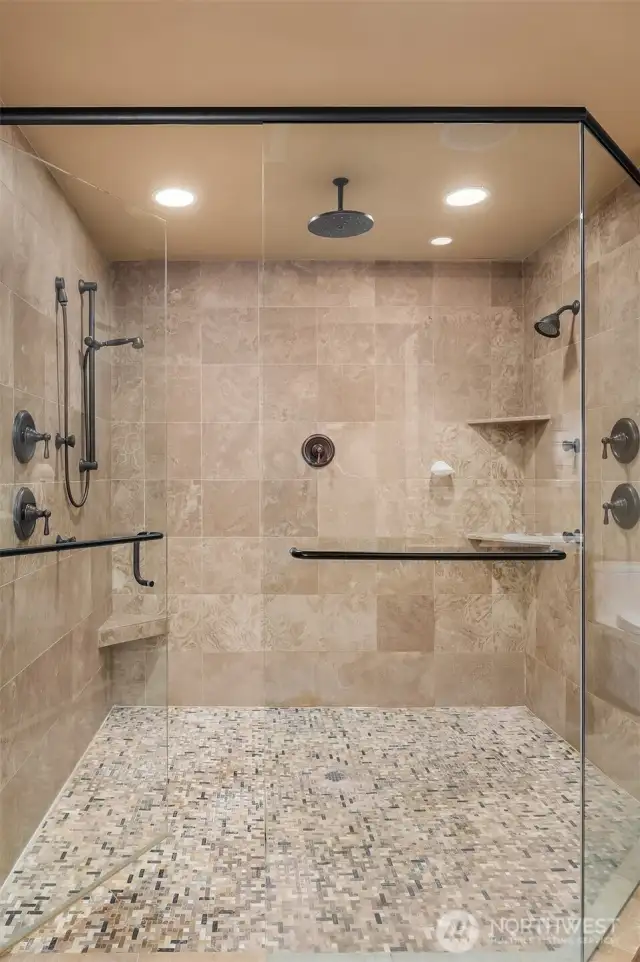 The large en suite spa-inspired bath with frame-less glass door double shower, Travertine tilework, heated floors, jetted tub, and huge cedar-lined walk-in closet.
