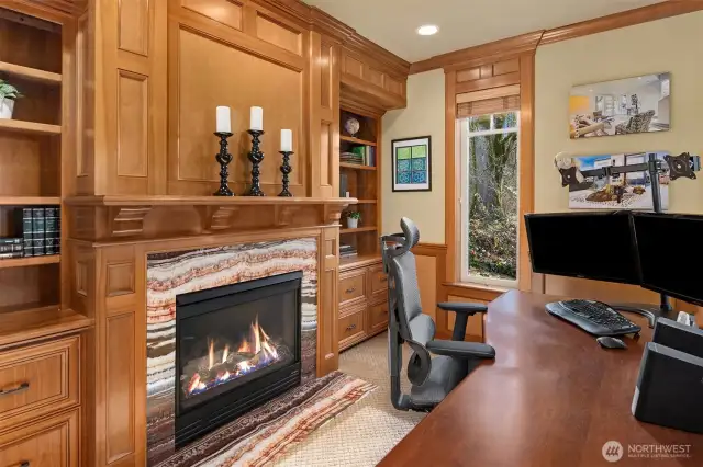 The office / library displays the elegant and warm craftsmanship of the home with a fireplace wrapped in polished marble tile, a stunning mantle and built in cabinets and shelves.