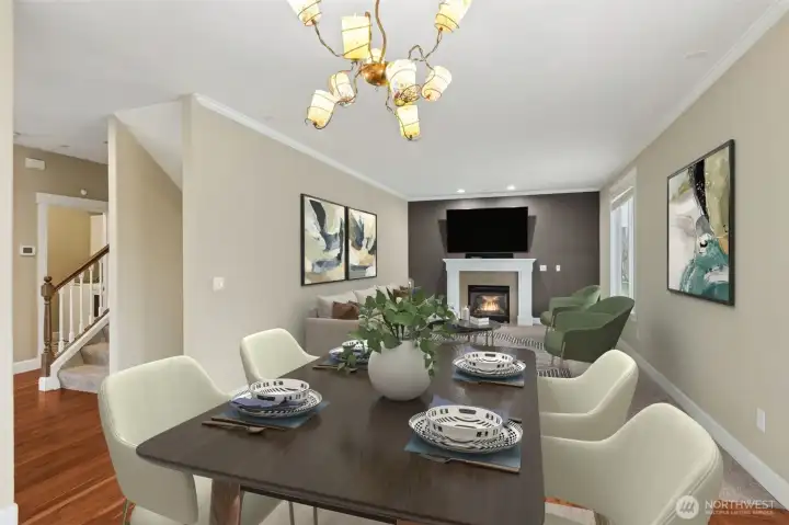 This family room is where everything comes together. From the dining area, you get a clear view of both the downstairs and upstairs staircases, which adds a sense of openness and connection across levels. The gas fireplace with a classic white mantle anchors the room, with a mounted TV above that stays with the home.