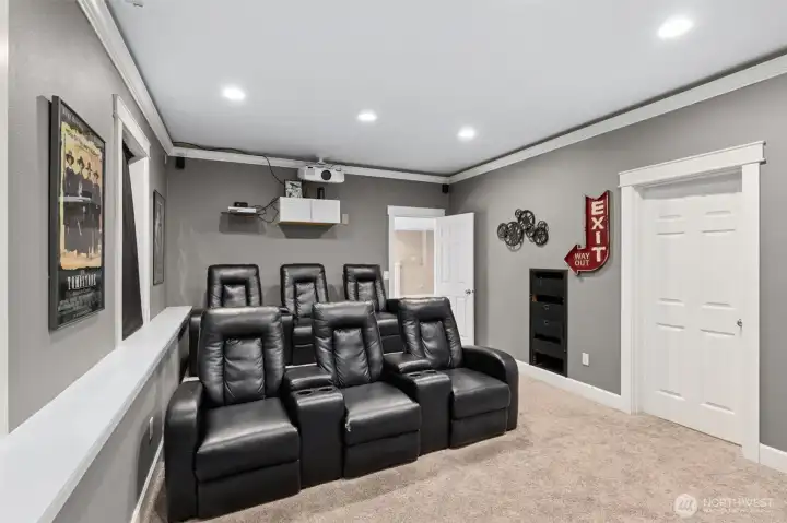 This angle really shows how legit this theater room is. All six reclining chairs are lined up and ready, with stadium style seating so no one’s stuck staring at the back of someone’s head. You get a clear view of the included projection screen from every seat, and just off to the side is a door to a massive 9 by 14 storage room that creates an amazing flexible option for storing away your necessities or to use as a craft room, workout space or window-free gaming zone.