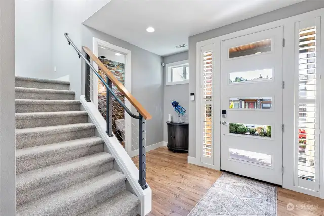 Light & open entry with contemporary paint colors and high ceilings. Power room is off to the right. Gorgeous flooring too.