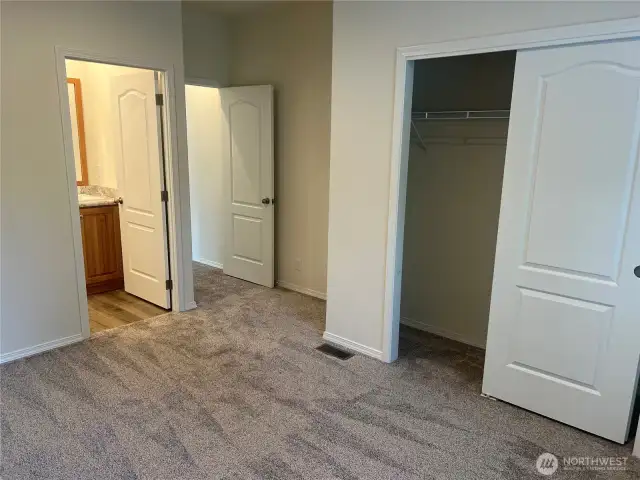 Primary bedroom closet and bathroom entrance.