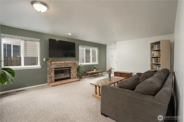 Lots of natural light shimmers as you enter the townhome.  The brick fireplace and hearth are a lovely accent to the space.