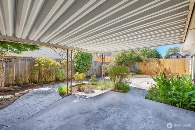 Covered patio area with view of the beautiful back yard. Custom cement side walk from front door area, thru gate all around the side and back of the home. Mature plants and shrubs bring color to this area.