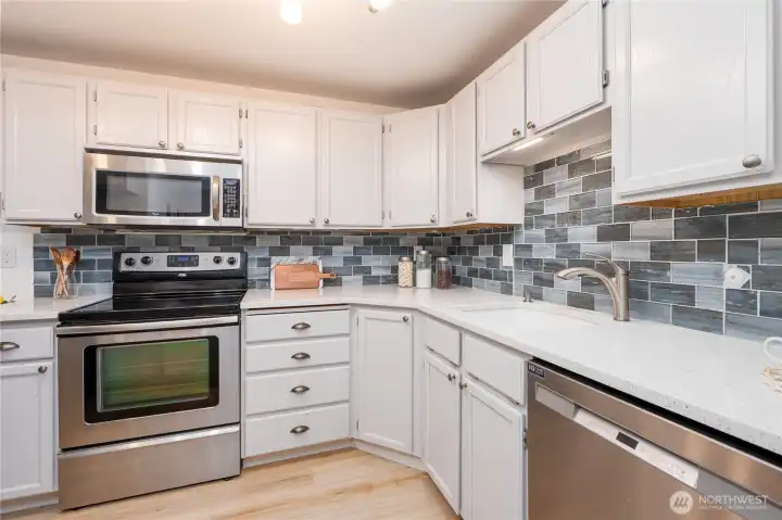Kitchen with new backsplash and stainless steel appliances.