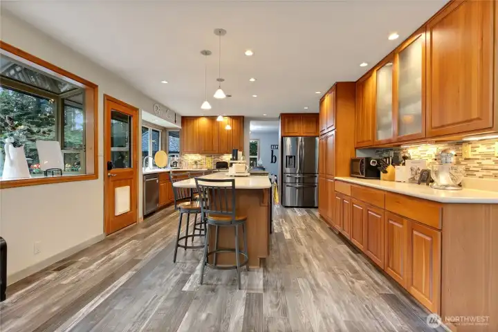 Kitchen with a door to the back patio. Lots of cabinet storage and large oversize island.