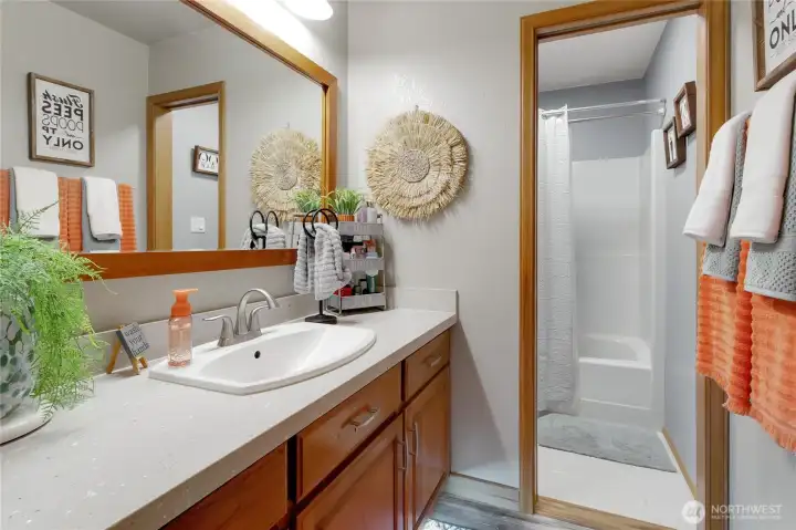Full bathroom with separate toilet, tub and shower behind a pocket door.
