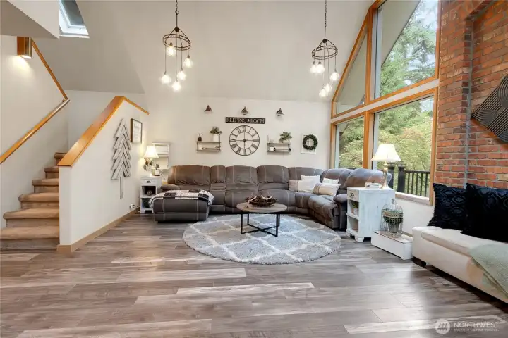 Large oversized living room with functional and decorative lighting. Stairs go up to the Loft an Primary Suite.