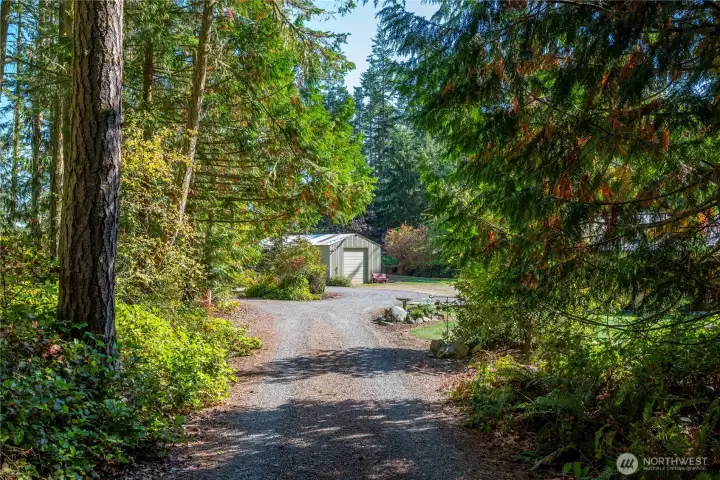 The large entrance opens into a circle drive, in the distance is the detached powered 720 sqft garage.