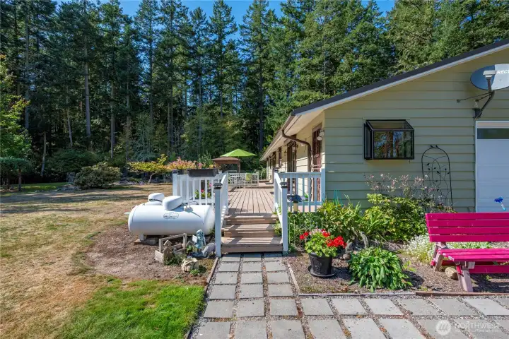 Charming garden path leading to the large back deck. The garden window is off the laundry room.