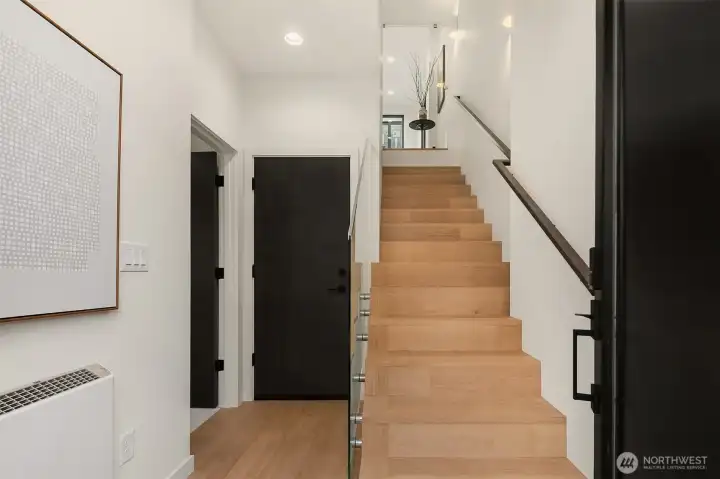 Entry with Hardwood floors and Glass Stair Railing.
