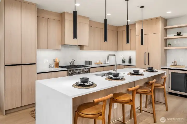 Quartz Countertops with Waterfall Island and Backsplash. Integrated Fisher Paykel French Door Refrigerator and Beverage Fridge.