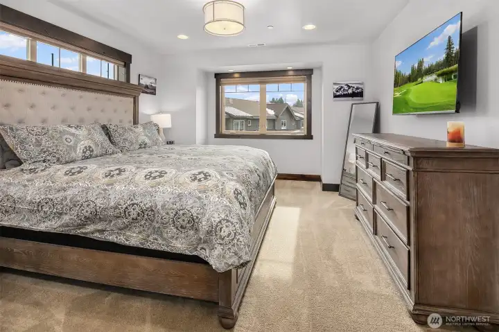 Primary bedroom with King Bed, ceiling fan, walk in closet and ensuite bath. Large TV