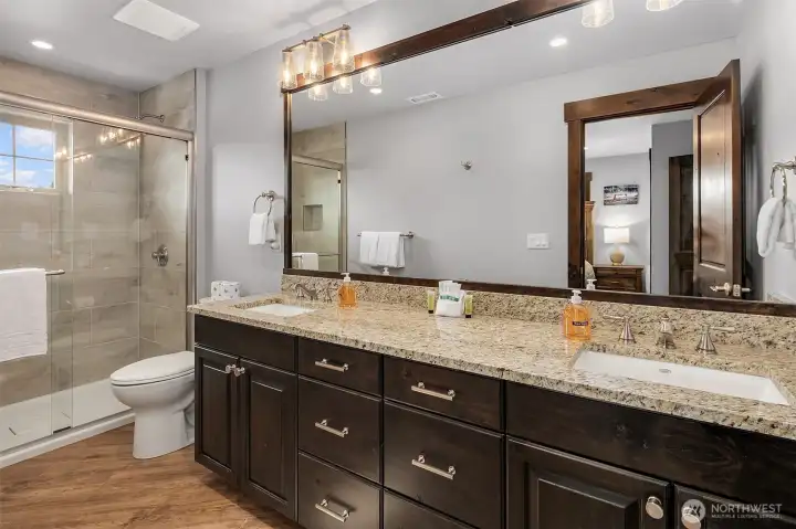 Primary suite with 2 sinks and large walk in shower and tile floors
