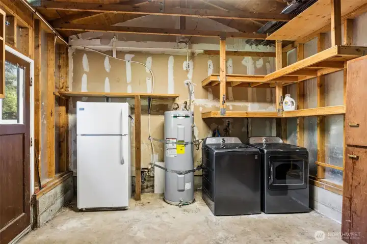 Laundry, water heater and refrigerator in garage.