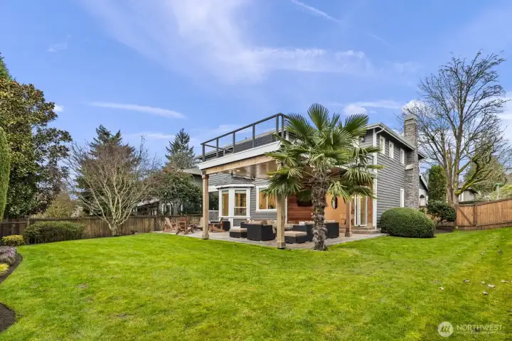 The large, level & fully fenced yard is surrounded by manicured greenery for a lush, private oasis.