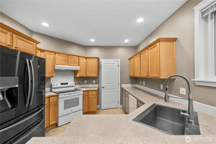 Bright and functional kitchen with ample cabinetry, generous counter space, recessed lighting, and a convenient breakfast bar. Open to the dining area, this space is designed for easy everyday living and effortless entertaining. Bright and functional kitchen with ample cabinetry, generous counter space, recessed lighting, and a convenient breakfast bar. Open to the dining area, this space is designed for easy everyday living and effortless entertaining.