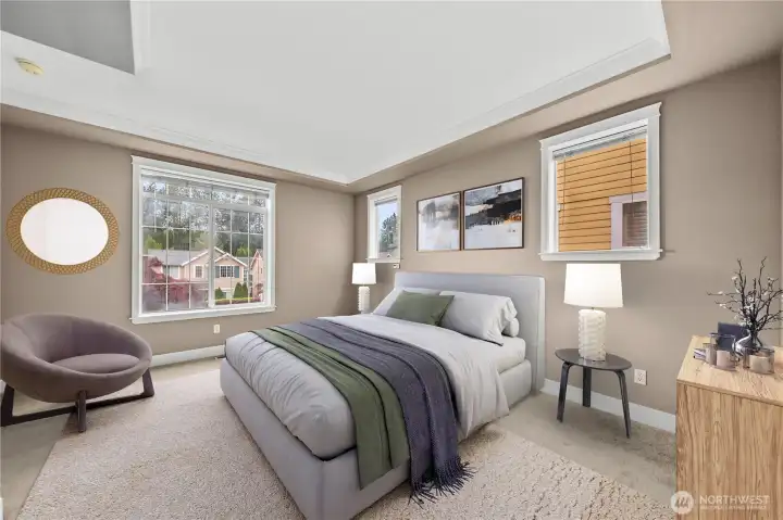 Comfortable and spacious main-level primary bedroom featuring a tray ceiling, large windows, and beautiful natural light. A peaceful retreat with an open and airy feel. Comfortable and spacious main-level primary bedroom featuring a tray ceiling, large windows, and beautiful natural light. A peaceful retreat with an open and airy feel.