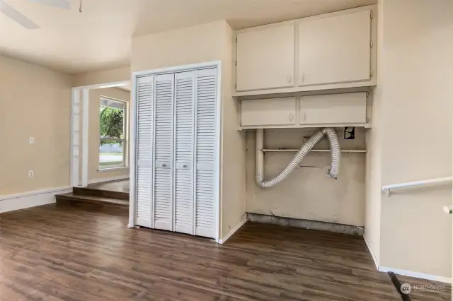 The convenient laundry center has easy-access in the family room, with a quad of storage cabinets above to keep things tidy and within easy reach.