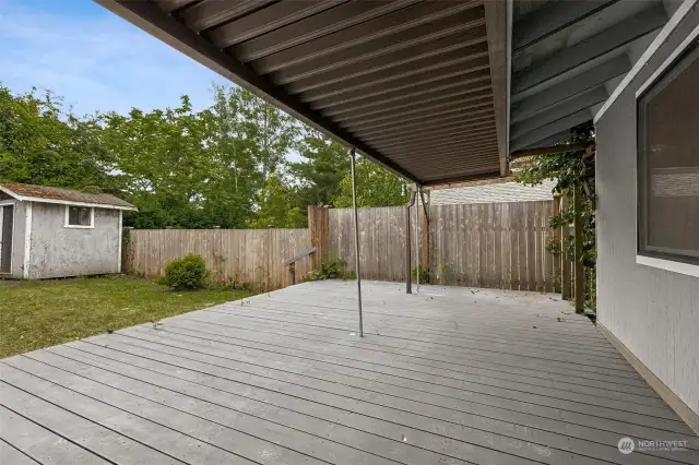Just off of the dining room, the slider opens to this covered backyard deck, providing year-round options for an outdoor cooking or gathering venue.