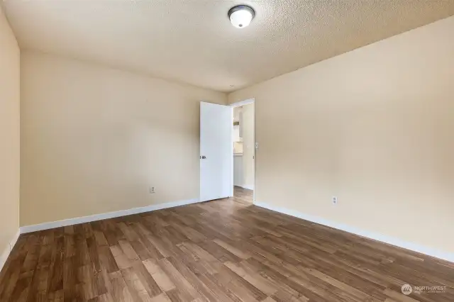 The warm tones of the new interior paint  in this 2nd bedroom will mesh well with contemporary or classic décor styles, along with the rich wood floor vibes.