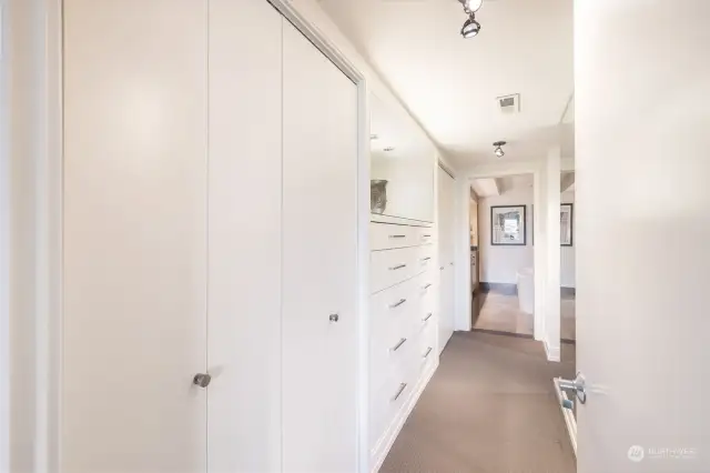 Entry to primary ensuite, with multiple closet options and built-ins.