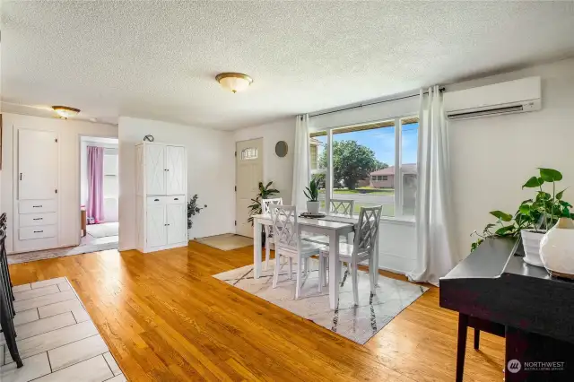 Airy and well-lit, this living/dining room is a place for everyone to gather during the day. An area rug helps set the dining area apart from the rest of the living room music studio area.