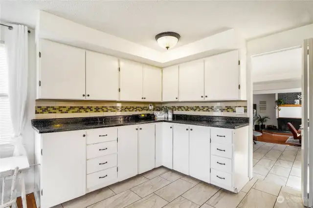 Additional counter space and extra cabinets provide even more storage in the kitchen, with the tile flooring seamlessly continuing into the laundry and office areas.