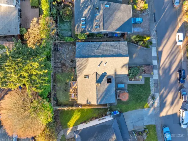 Aerial view showing the fully fenced yard, west-facing deck and 2 patios (1 facing East on the front, and 1 facing West in the back with a firepit).