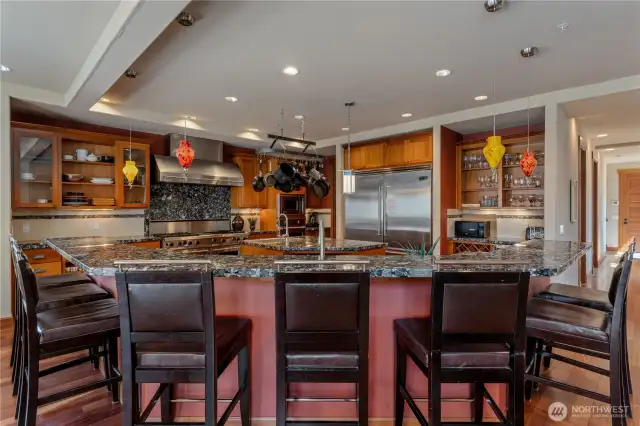Kitchen view 3 w/ Viking® Professional appliances, w/ sit up bar, wood cabinetry, walk-in pantry and granite countertops. overlooking the view dining room and Great Room w/ glass sliding doors that open onto the waterfront deck and outdoor living area.