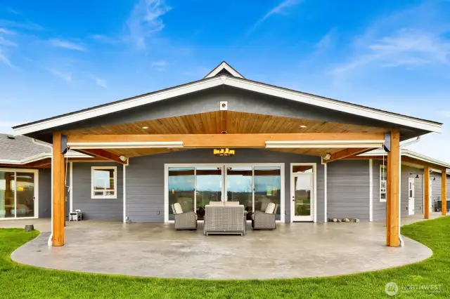 Whether you're hosting guests or enjoying a quiet weeknight dinner, it’s easy to relax comfortably on your expansive covered patio. Tastefully designed with stunning cedar ceilings, a striking chandelier, and a stamped concrete floor, this outdoor retreat is as functional as it is beautiful. It features built-in outdoor speakers, pull-down shades for protection from the westerly sun, and is pre-plumbed for both an outdoor kitchen and gas fireplace. Just off to the left, sliding doors from the primary bedroom open to a future hot tub area—also conveniently pre-plumbed and ready for installation.